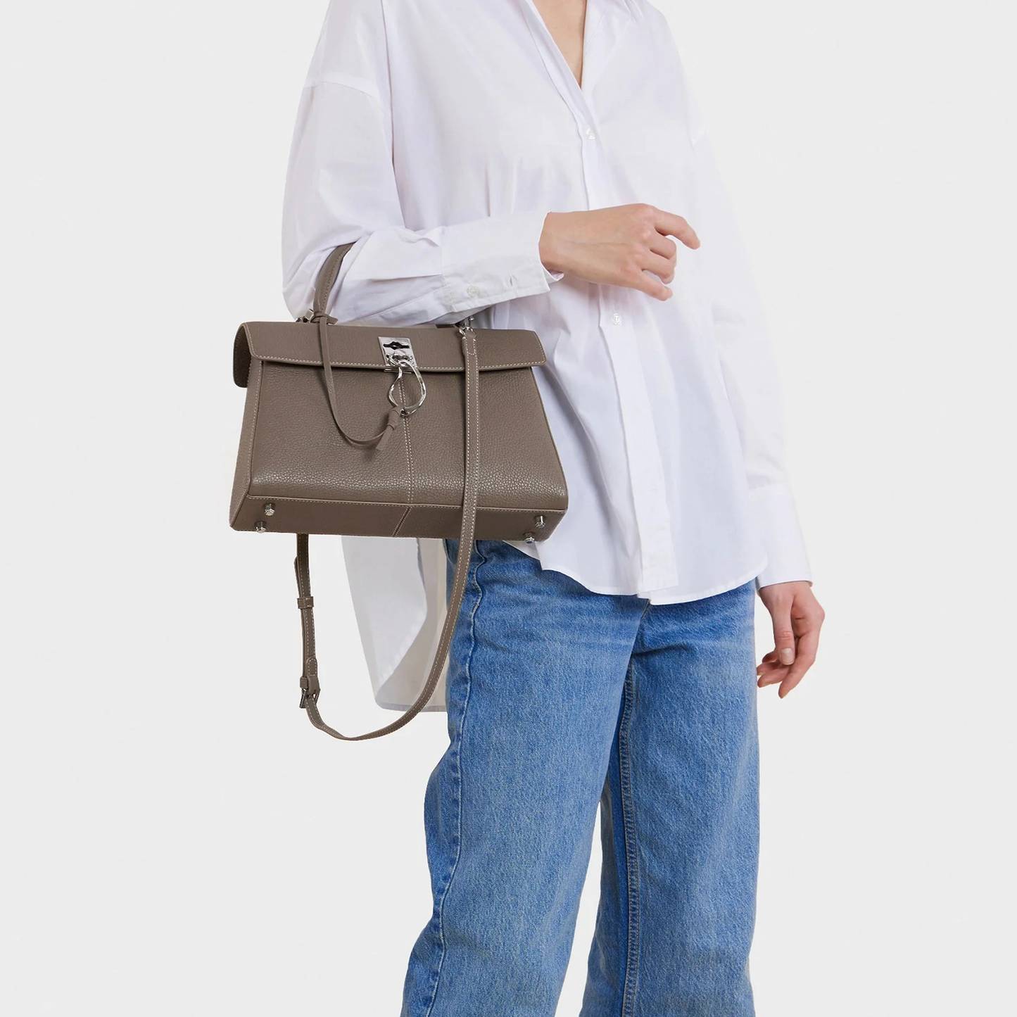 Muted Earthy Taupe Grain Textured Sleek Trapezoid Flap Tote With Distinctive Curved Ring Metal Clasp And Base Protective Studs