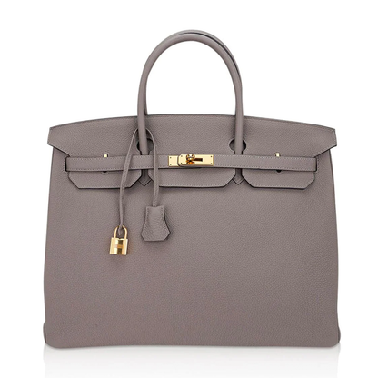 Muted Ash Gray Pebble Grain Large Trapezoid Hand Tote With Warm Polished Golden Twist Lock Hardware And Matching Suspended Engraved Metal Padlock Charm