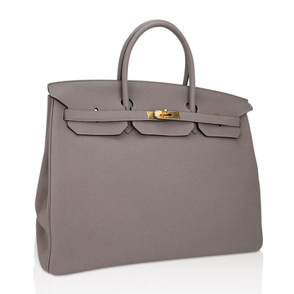 Muted Ash Gray Pebble Grain Large Trapezoid Hand Tote With Warm Polished Golden Twist Lock Hardware And Matching Suspended Engraved Metal Padlock Charm
